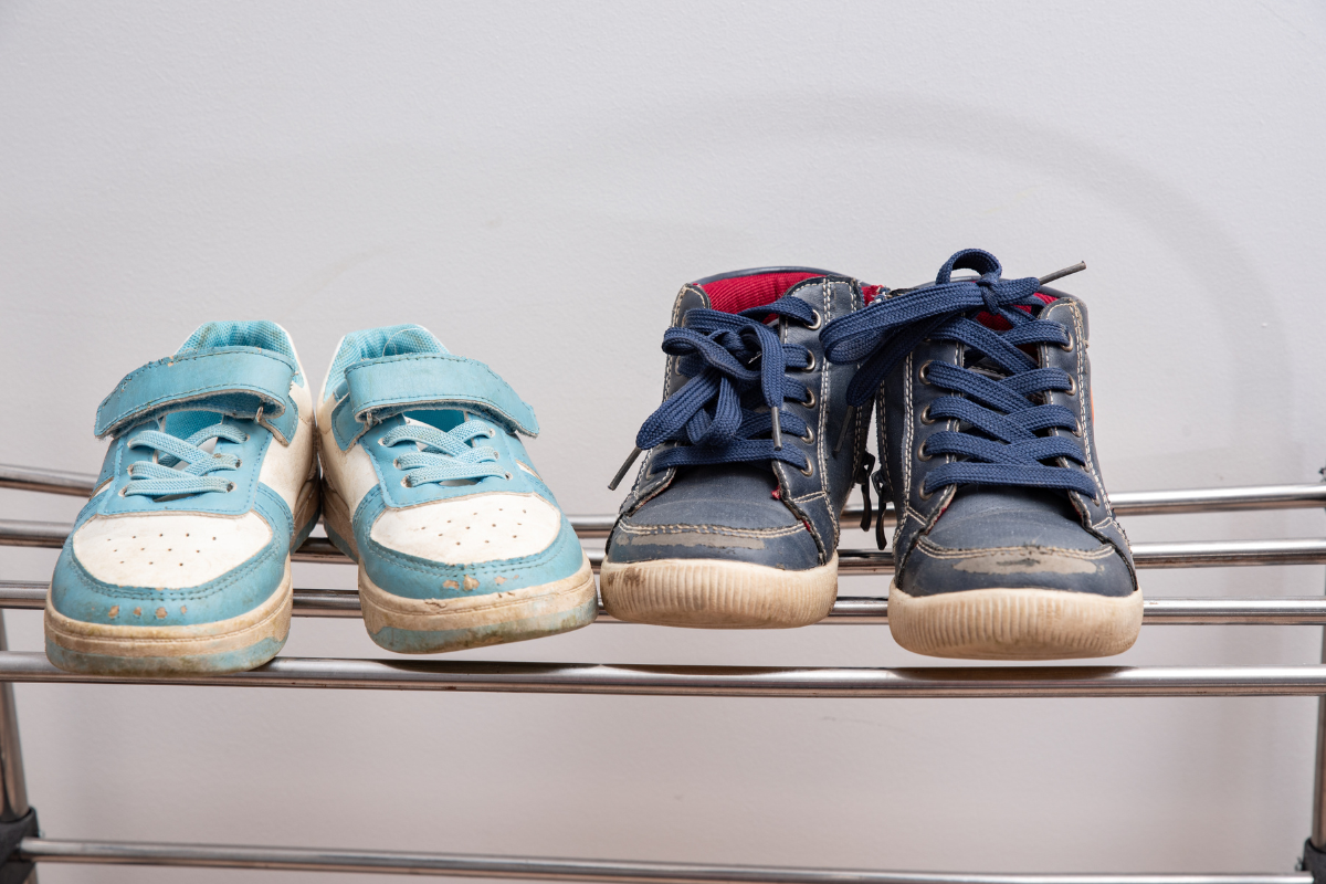 Dirty shoes stand on the shelf. Decluttering and cleaning