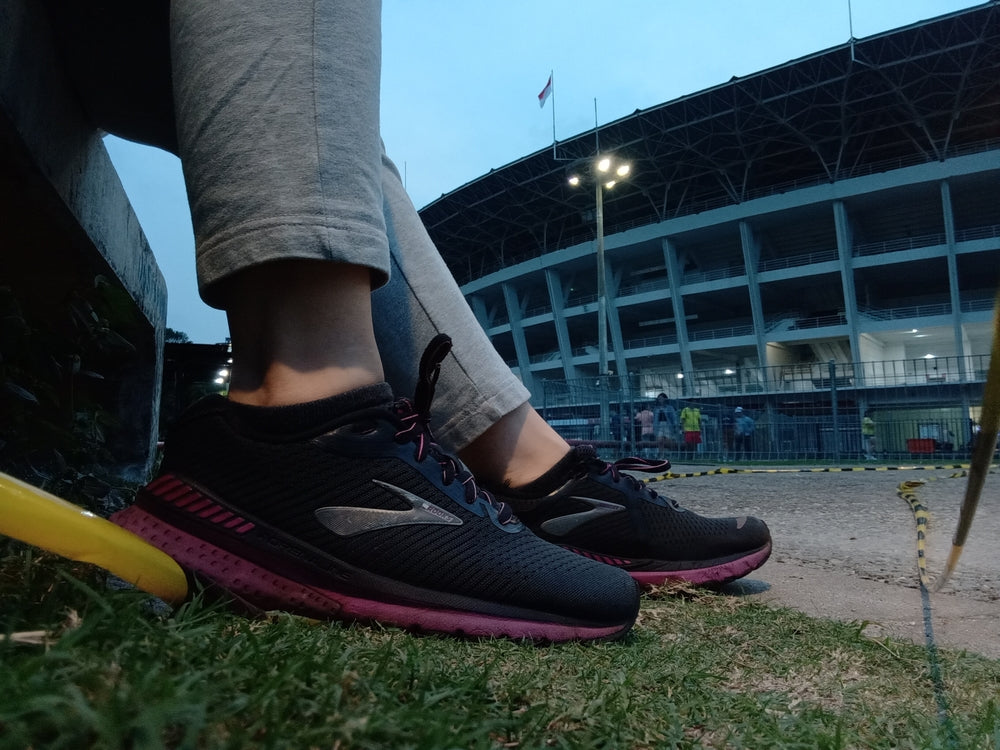 dirty Brooks shoes in the grass outside of stadium