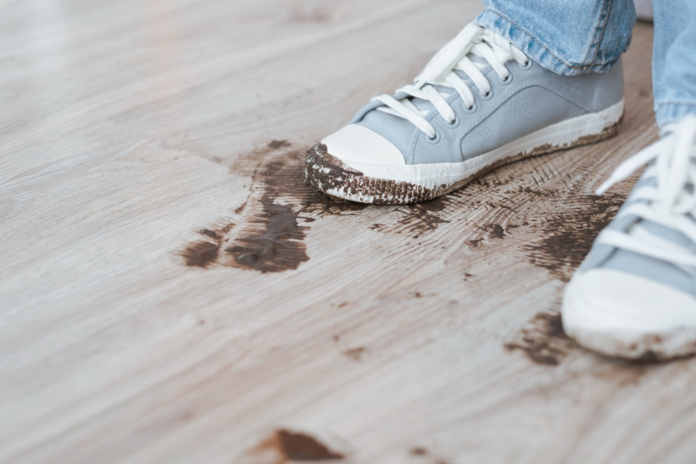 pair of muddy sneakers with white soles